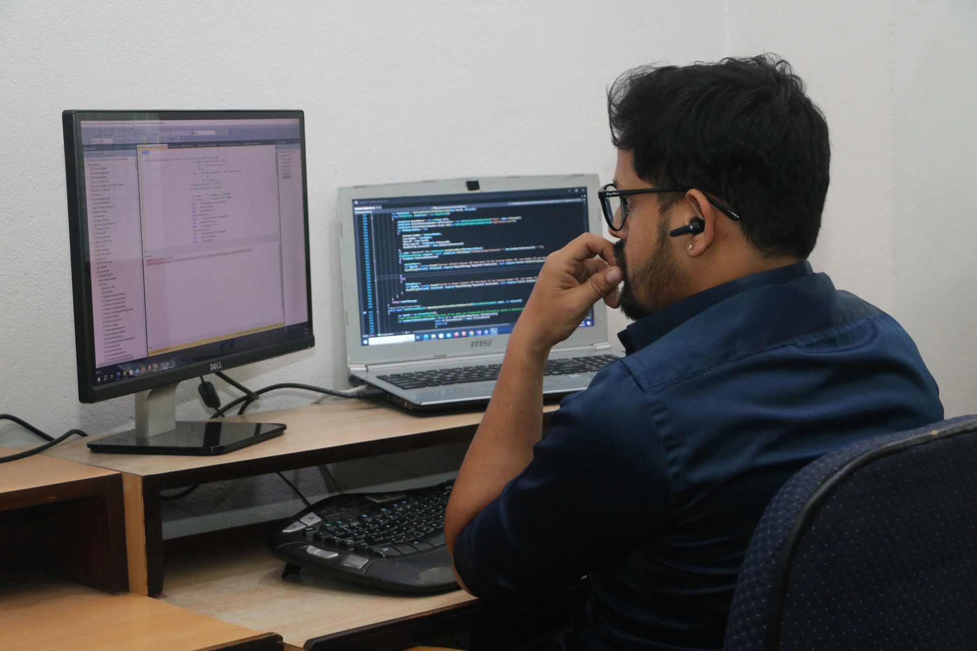 Database administrator working on multiple monitors